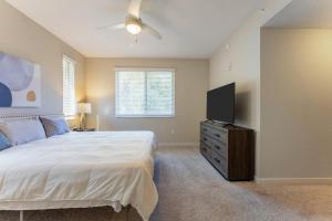 a bedroom with a bed and a flat screen tv at Spacious 3BR | Pool, Gym, Near Beach & Speedway in Daytona Beach +69 photos