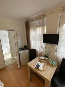 un piccolo soggiorno con tavolo e TV di Apartman Mia 1 Igalo Centar a Igalo