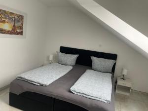 een slaapkamer met een bed met twee kussens erop bij Sunshine FeWo in Rust