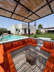 a patio with orange furniture and a swimming pool at Villa soléa - Route Ouarzazate in Marrakesh