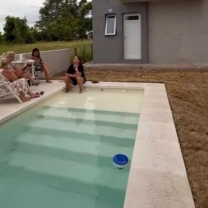 een groep vrouwen die rond een zwembad zitten bij cabañas RIALTO in Villa Amancay