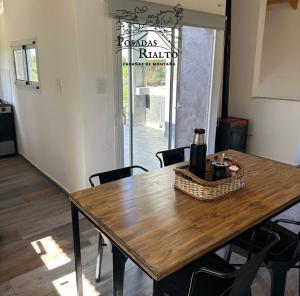 een houten tafel met een fles en een mand erop bij cabañas RIALTO in Villa Amancay