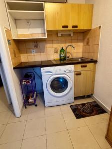 een keuken met een wasmachine en een wastafel bij Cosy studio plages Antibes in Antibes +1 foto