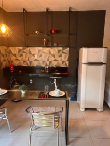 een keuken met een tafel en een koelkast bij Pousada Flat Lourdes Residence in Angicos