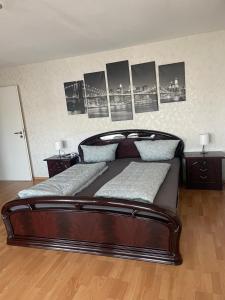een slaapkamer met een houten bed met foto's aan de muur bij Sunshine FeWo in Rust