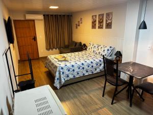 una camera da letto con un letto, un tavolo e una scrivania di Vivaê Studio a Vila Velha