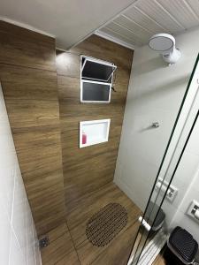 una cabina doccia in un bagno con pareti e pavimenti in legno di Vivaê Studio a Vila Velha