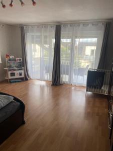 a living room with a wooden floor and sliding glass doors at Sunshine FeWo in Rust +28 photos
