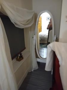 een kamer met een spiegel en een bed bij Owls Roost in Stowmarket