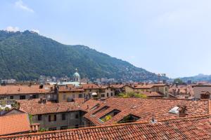 una città con tetti e una montagna sullo sfondo di Hotel Plinius a Como