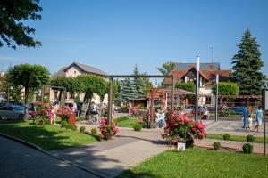 a park with flowers and people on a street at Aura Baltic in Rewal