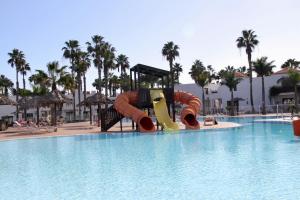 a slide in the middle of a pool at a resort at Casa Nube in Corralejo
