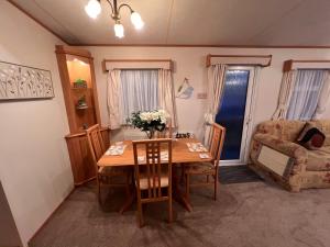 a living room with a table and a chair and a couch at A and C Coastal Hideaway Private Decking in Colchester