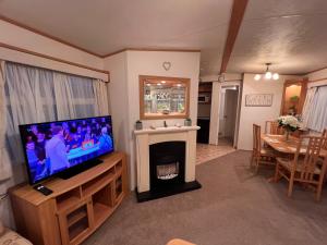 a living room with a television and a fireplace at A and C Coastal Hideaway Private Decking in Colchester