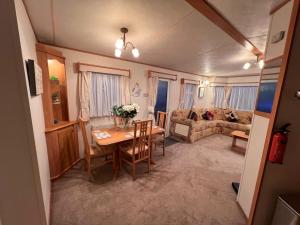 a living room with a table and a couch at A and C Coastal Hideaway Private Decking in Colchester +5 photos