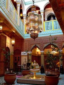 un grand hall avec un lustre dans un bâtiment dans l'établissement Maison Do, à Marrakech