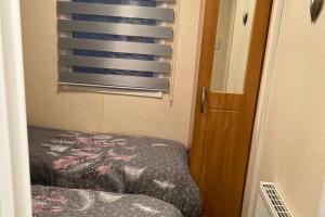 a small bedroom with a bed and a window at A and C Coastal Hideaway Private Decking in Colchester