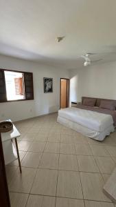 a bedroom with a large bed and a tiled floor at Casa Amarela in Serra