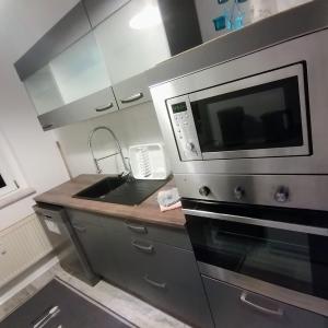 a kitchen with a sink and a microwave at Ferienwohnung Lindena - Lausitz in Doberlug-Kirchhain