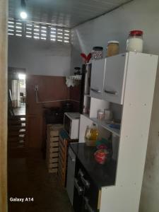 a kitchen with a white refrigerator and a black counter top at Casa para alugar para o Carnaval in Recife