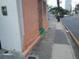 a building with a green door on the side of a street at Casa para alugar para o Carnaval in Recife
