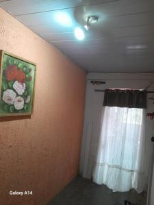 a room with a curtain and a painting of flowers at Casa para alugar para o Carnaval in Recife +2 photos