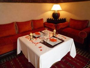 una mesa en una habitación con sofá y una mesa con velas en Maison Do, en Marrakech
