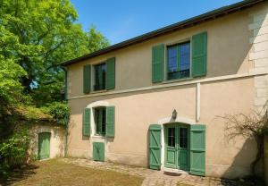 a house with green shutters on it at Echappée verte avec piscine et clim proche de Paris in Vert-le-Grand
