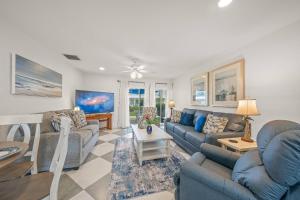 a living room with blue couches and a table at Jamaica Royale Beach Villa in Siesta Key +42 photos