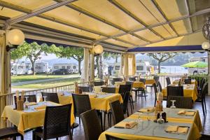 a dining room with yellow tables and chairs at Camping Solcio in Lesa