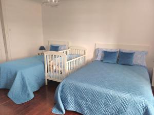 a bedroom with two twin beds and a crib at SEASTAR nº36 in Horta