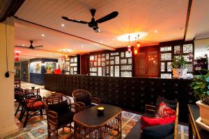 a restaurant with tables and chairs and a ceiling fan at Baan Chart in Bangkok