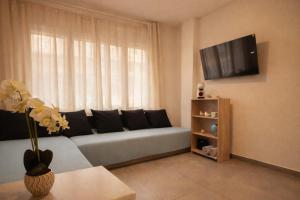 een woonkamer met een bank voor een raam bij Alojamiento cerca de la Playa in Roses