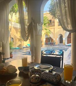 a table with food on it with a view of a building at Chambres Émeraude et Rubis - Riad Lotus Bleu in Fès +22 photos