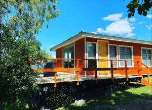 a large wooden house with a large porch at Cabaña Lago Ranco in Ranco
