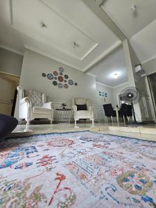 a living room with white furniture and a large rug at Witte Huis Cirendeu in Cipayung Tiga