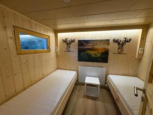 a small room with two beds and a window at Zillertalerhütte in Aschau