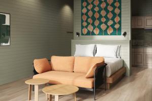 a bed and a couch in a room with two tables at Outbound Yosemite in Oakhurst
