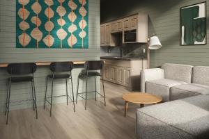 a kitchen with a bar with stools and a couch at Outbound Yosemite in Oakhurst