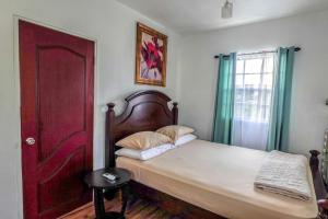 een slaapkamer met een bed en een rode deur bij Modern Cozy Apartment in Buckleys