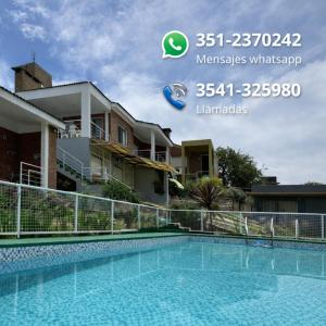 een foto van een zwembad voor een huis bij Cabañas Casitas De Emma in Villa Carlos Paz