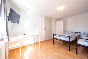 een kamer met een bed, een tafel en een tv bij Nest-Unterkunft in Bad Überkingen