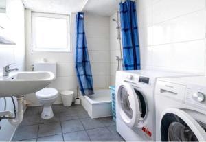 een badkamer met een wasmachine en een wastafel bij Nest-Unterkunft in Bad Überkingen