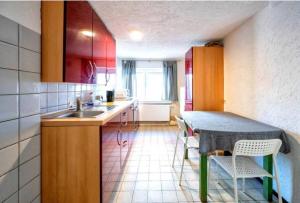 een keuken met een spoelbak en een tafel met stoelen bij Nest-Unterkunft in Bad Überkingen