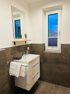 une salle de bain avec un lavabo blanc et une fenêtre dans l'établissement Berghoamat Nauders, à Nauders