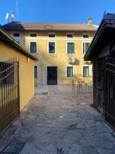 ein gelbes Gebäude mit einem Innenhof mit Tischen und Stühlen in der Unterkunft Dolomiti Lodge - Fit & Well in Belluno