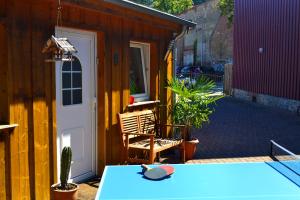 un patio con una mesa, una silla y una puerta en Bungalow am Bach - zwischen Brocken und Schloß en Wernigerode