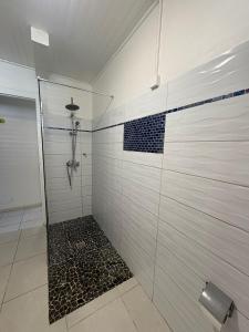 La salle de bains est pourvue d'une douche et de carrelage noir et blanc. dans l'établissement Villa JOSAMY Charmante Villa avec Piscine à Deux Pas de la Mer, à Sainte-Luce