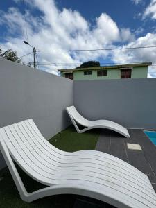 a white bench sitting on the side of a wall at Villa JOSAMY Charmante Villa avec Piscine à Deux Pas de la Mer in Sainte-Luce