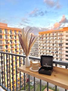 a table with a laptop on a balcony with buildings at Maison kh in Suba